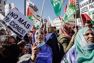 Un grupo de personas participa con pancartas y banderas en una manifestación contra la violación de derechos en el Sáhara Occidental. EP