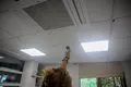 Una mujer enciende el aire acondicionado en una oficina