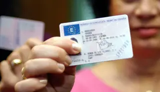 Una mujer posa con el carnet EP