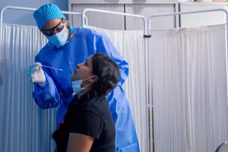 Un trabajador sanitario protegido le realiza a una mujer un test PCR en el Centro de Especialidades Carabanchel Alto. En Carabanchel, Madrid, (España), a 17 de agosto de 2020.