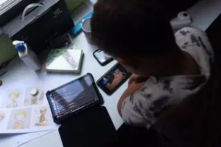 Un niño usa el teléfono móvil y una tablet. Eduardo Parra Europa Press Archivo