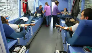 Personas donando sangre en la unidad móvil