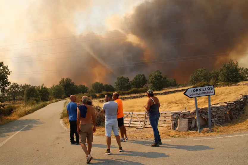 Un grupo de personas mira el incendio cerca de Fornillos