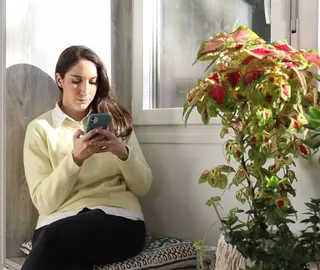 Una chica hace gestiones con el teléfono móvil. EP