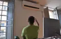 Un trabajador regulando el aire acondicionado