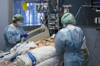 Personal sanitario atendiendo a un paciente ingresado en la Unidad de Cuidados Intensivos