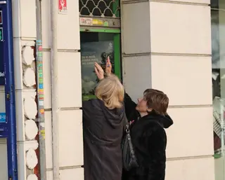 Dos mujeres abriendo la persiana de su negocio - EUROPA PRESS - Archivo