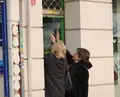 Dos mujeres abriendo la persiana de su negocio - EUROPA PRESS - Archivo