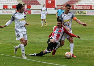Jorge Fernández ante dos defensores del Tudelano