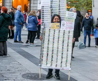 Archivo Una mujer vende décimos de Lotería de Navidad de la Administración de Doña Manolita, en Madrid (España), a 18 de noviembre de 2019.