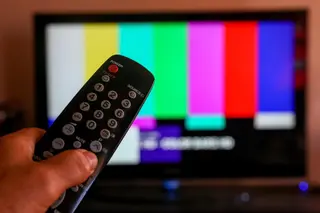 Una persona utiliza su mando de la televisión para buscar canales. Europa Press. Archivo