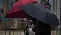 Viandantes pasean con el paraguas bajo la lluvia