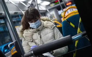Una mujer protegida con mascarilla montada en autobús. Foto Europa Press