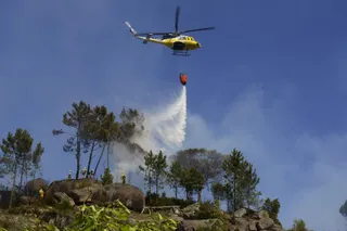 Archivo | Un helicóptero arroja agua sobre un incendio forestal