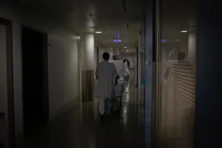 Un profesional sanitario traslada a un enfermo en un hospital