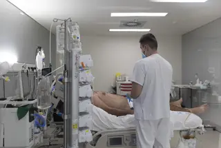 Un sanitario alrededor de un paciente ingresado en la UCI. Europa Press