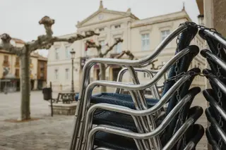 Las sillas de una terraza apiladas durante el cierre de la hostelería