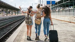 Tres jóvenes pasean junto a la vía del tren