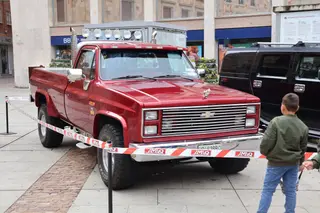 Niño observa uno de los coches expuestos en la feria