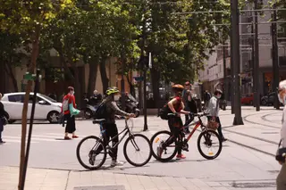 Jóvenes con mascarilla pasean con bicicleta