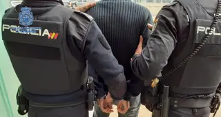 Dos agentes de la Policía Nacional trasladan a un detenido. EP. Archivo.
