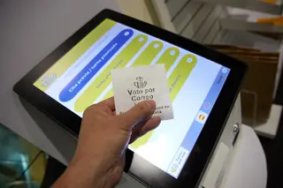 Una persona con un ticket de voto por correo en la oficina de Correos. Jesús Hellín. Europa Press
