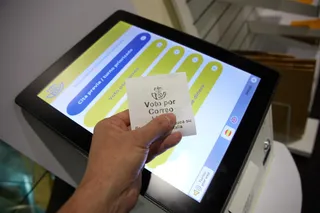 Una persona con un ticket de voto por correo en la oficina de Correos | EP