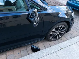 Retrovisor roto junto al coche dañado