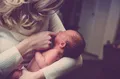 Una madre tiene cogido a su bebé. Facua. EP. Archivo