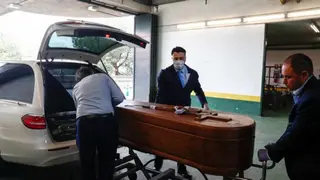 Varios trabajadores de los Servicios Funerarios introducen un féretro en el vehículo. EUROPA PRESS