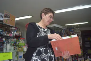 Pilar Manteca hojea un libro en su librería
