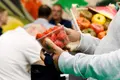 Un hombre comprando una caja de fresas. Archivo | EP
