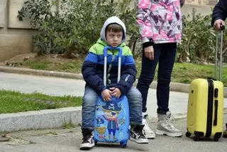 Un niño refugiado junto a su maleta. Foto EP