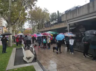 Personas bajo la lluvia en La Marina. Marcha Asprosub