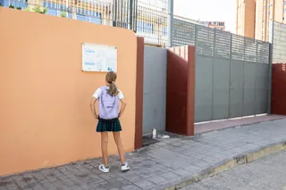 Una niña frente a la puerta del colegio. Archivo | EP