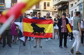 Un manifestante porta una bandera de España con un Toro durante la manifestación de apoyo a Ceuta