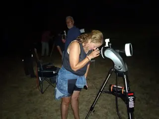 Una mujer observa a través de un telescopio. Archivo