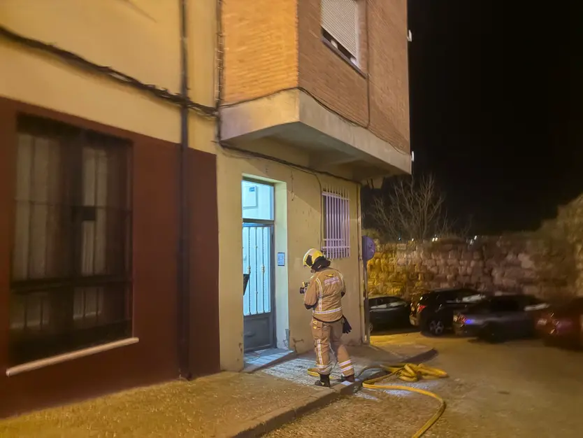 Uno de los bomberos desplazados a la puerta de la vivienda