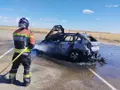Los bomberos sofocan el fuego en un coche ardiendo en la A-66 este domingo