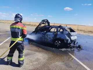 Los bomberos sofocan el fuego en un coche ardiendo en la A-66 este domingo