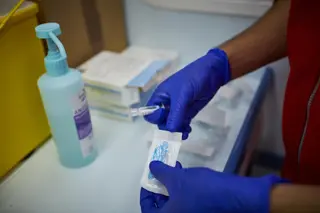 Un sanitario se prepara para administrar la vacuna contra la gripe EP
