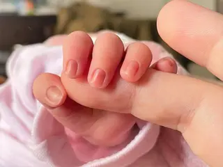 Un bebé de pocos días de edad coge el dedo de su madre. - EUROPA PRESS - Archivo