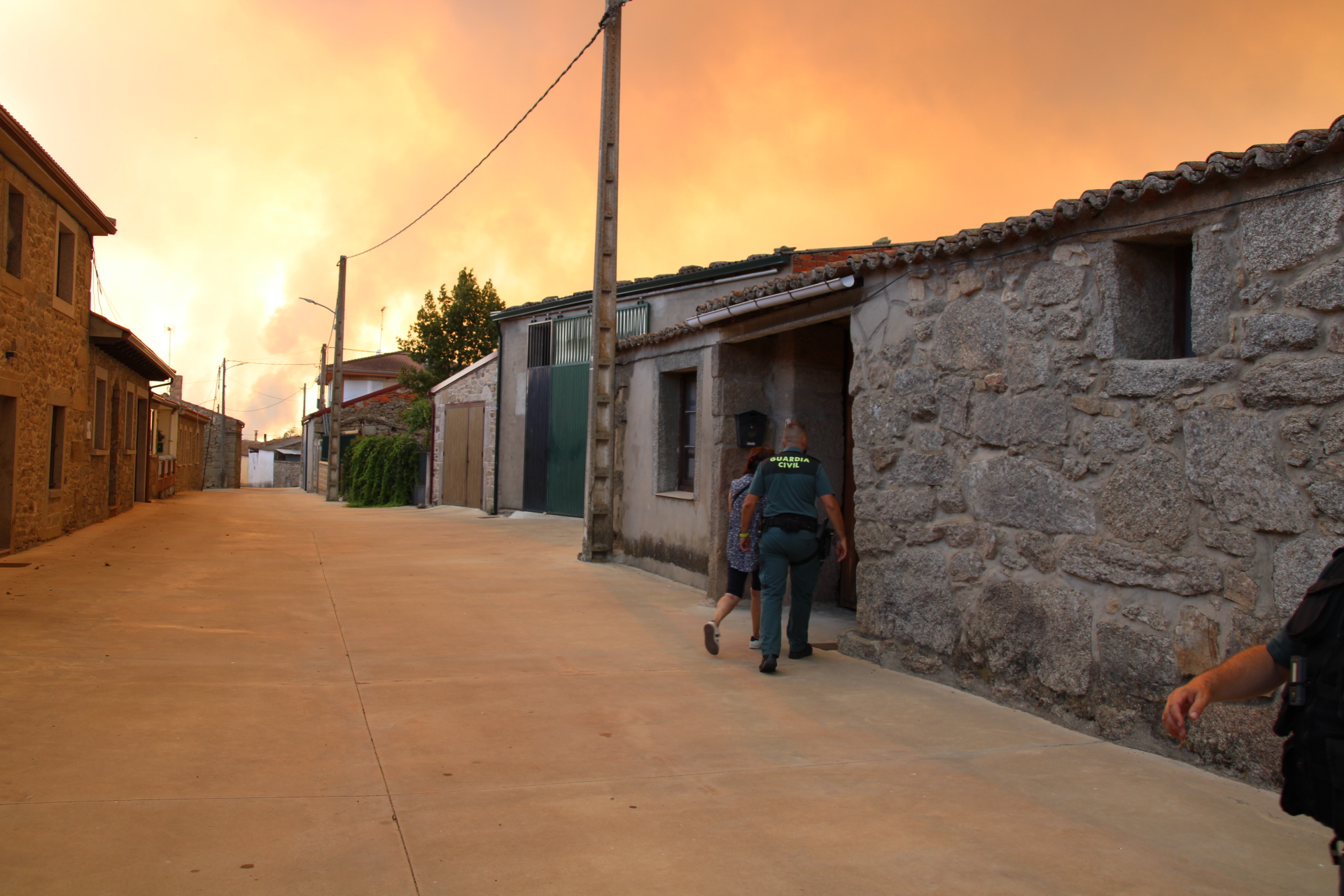Un agente acude a ayudar a una vecina en Muga de Sayago durante la evacuaci&oacute;n