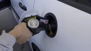 Persona repostando en una gasolinera. Archivo