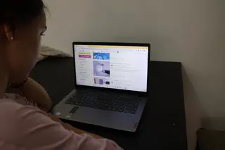 Una joven mira con preocupación los precios del alquiler en una página web