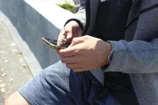 Un joven mira su móvil.