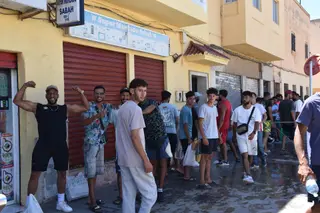Varias personas hacen cola en un punto de atención humanitaria | EP