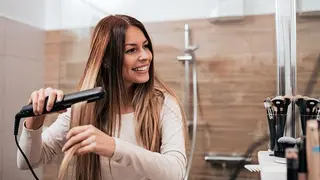 Mujer usando un alisador de pelo. Foto OCU