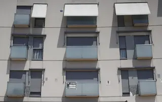 Cartel de 'se vende' en el balcón de un piso de un edificio