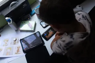 Un niño usa el teléfono móvil y una tablet. Eduardo Parra Europa Press Archivo